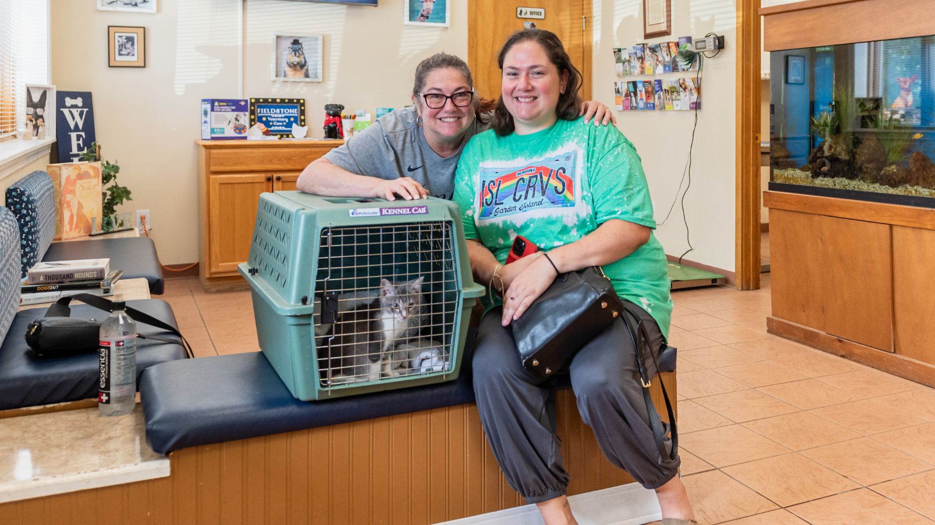 Vet and owner next to a kitten in a carrier
